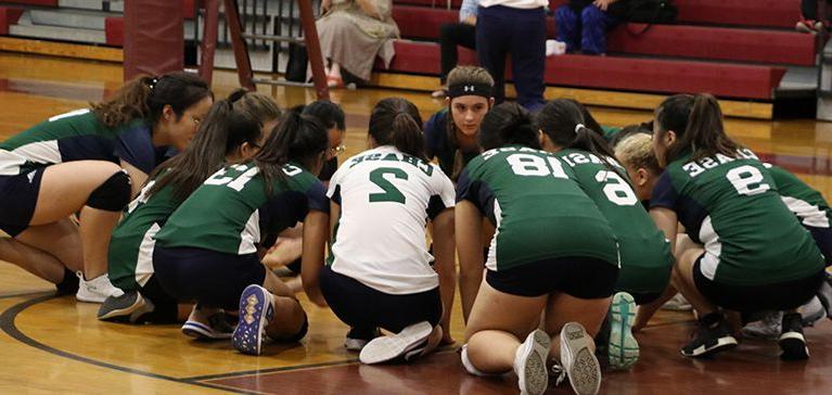 The Chase Collegiate Middle School girls' volleyball team huddles together before a match.